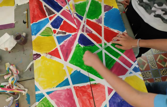 Un nen realitza una obra inspirada en la Fundació Stämpfli, amb molts colors.